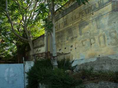 Solo spiando attraverso un arrugginito cancello laterale � possibile scorgere la sbiadita scritta a caratteri cubitali dipinta su una delle facciate: �Societ� italiana petrolifera Nafta. Deposito�
